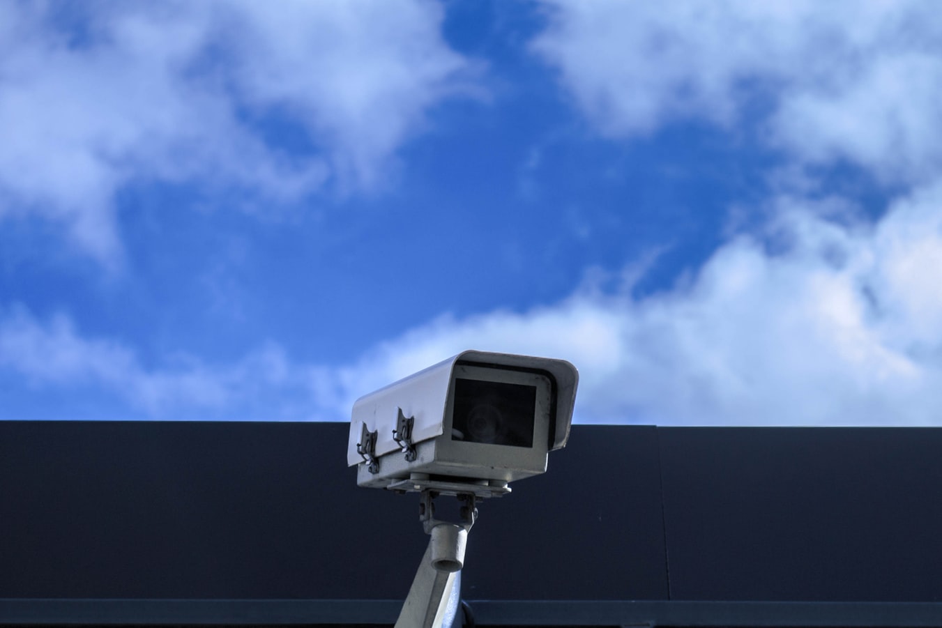 A security camera posted on the top of a building